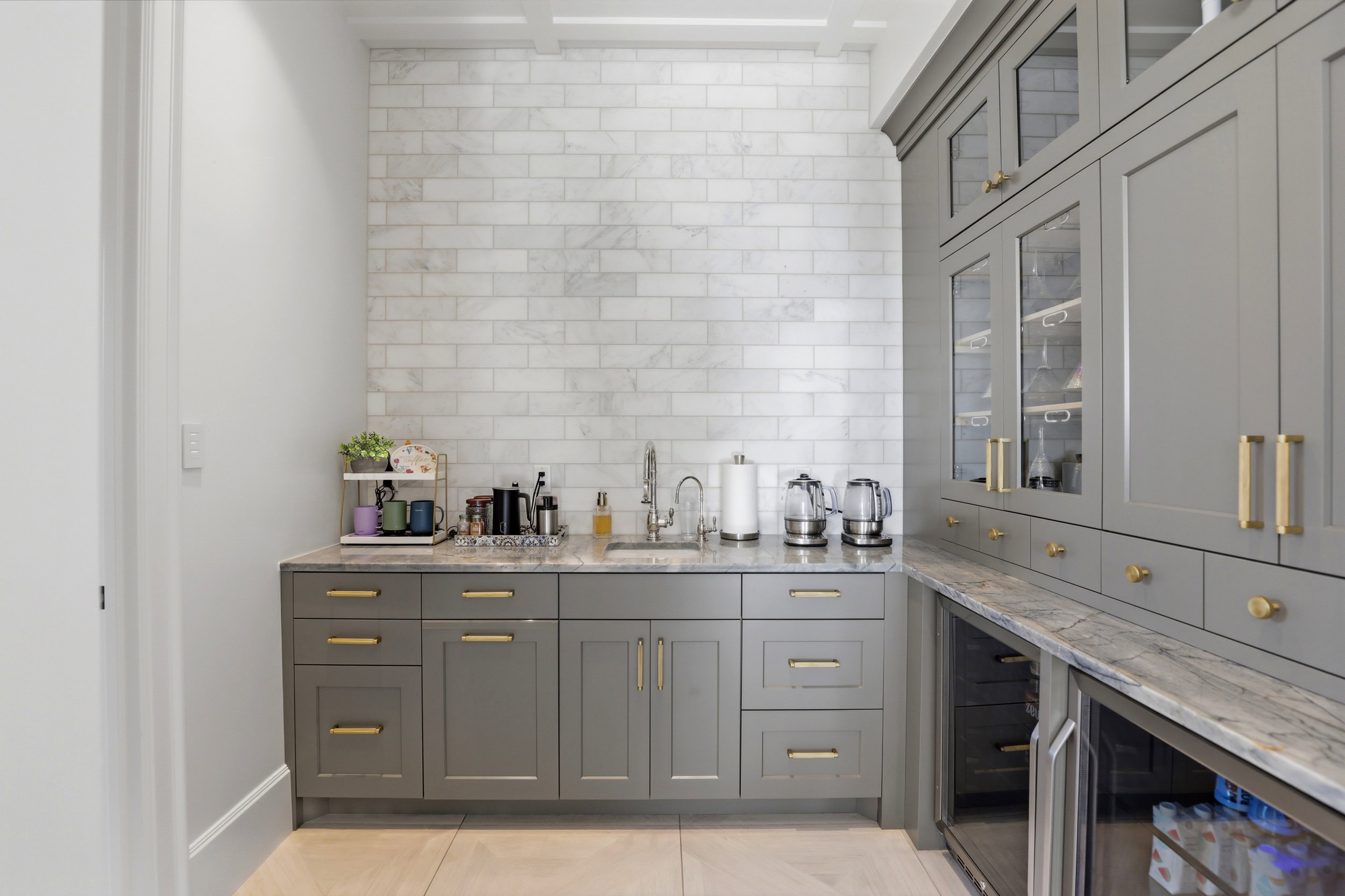 Bar featuring gray cabinets, light stone countertops, glass fronted cabinets, and beverage cooler