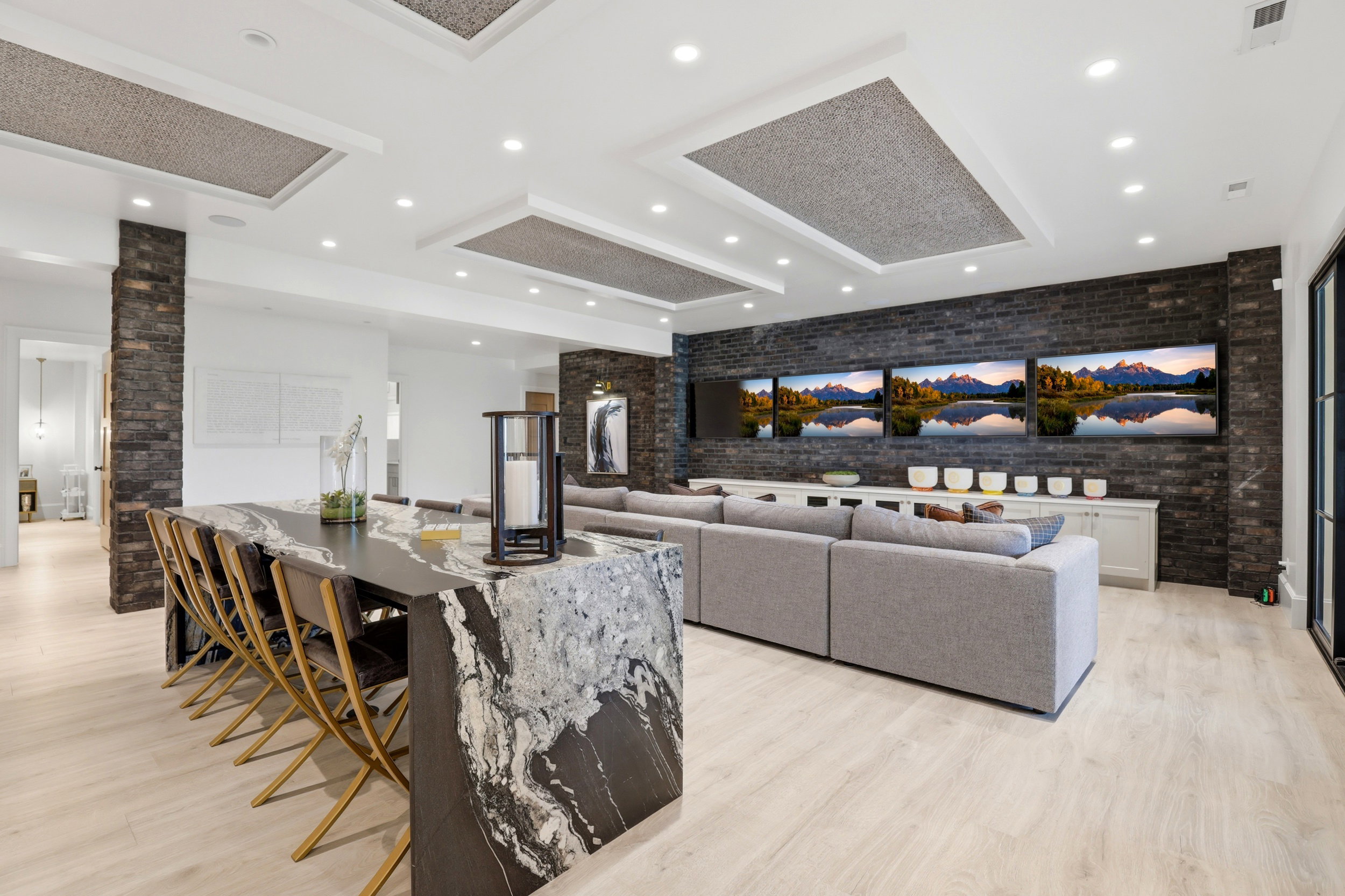 Living area with brick wall, light wood-type flooring, and recessed lighting