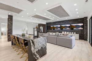 Living area with brick wall, light wood-type flooring, and recessed lighting