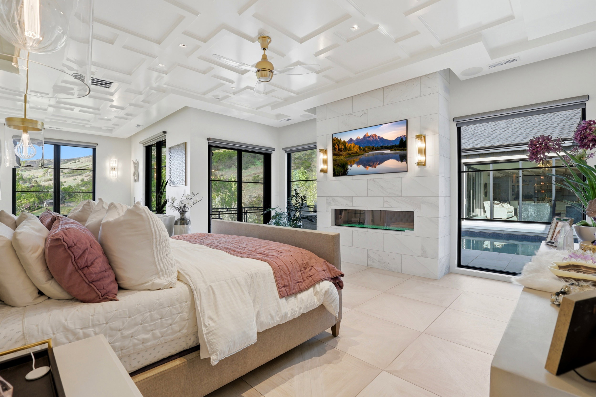 Bedroom featuring access to outside, coffered ceiling, a tile fireplace, and light tile patterned floors