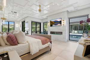 Bedroom featuring access to outside, coffered ceiling, a tile fireplace, and light tile patterned floors