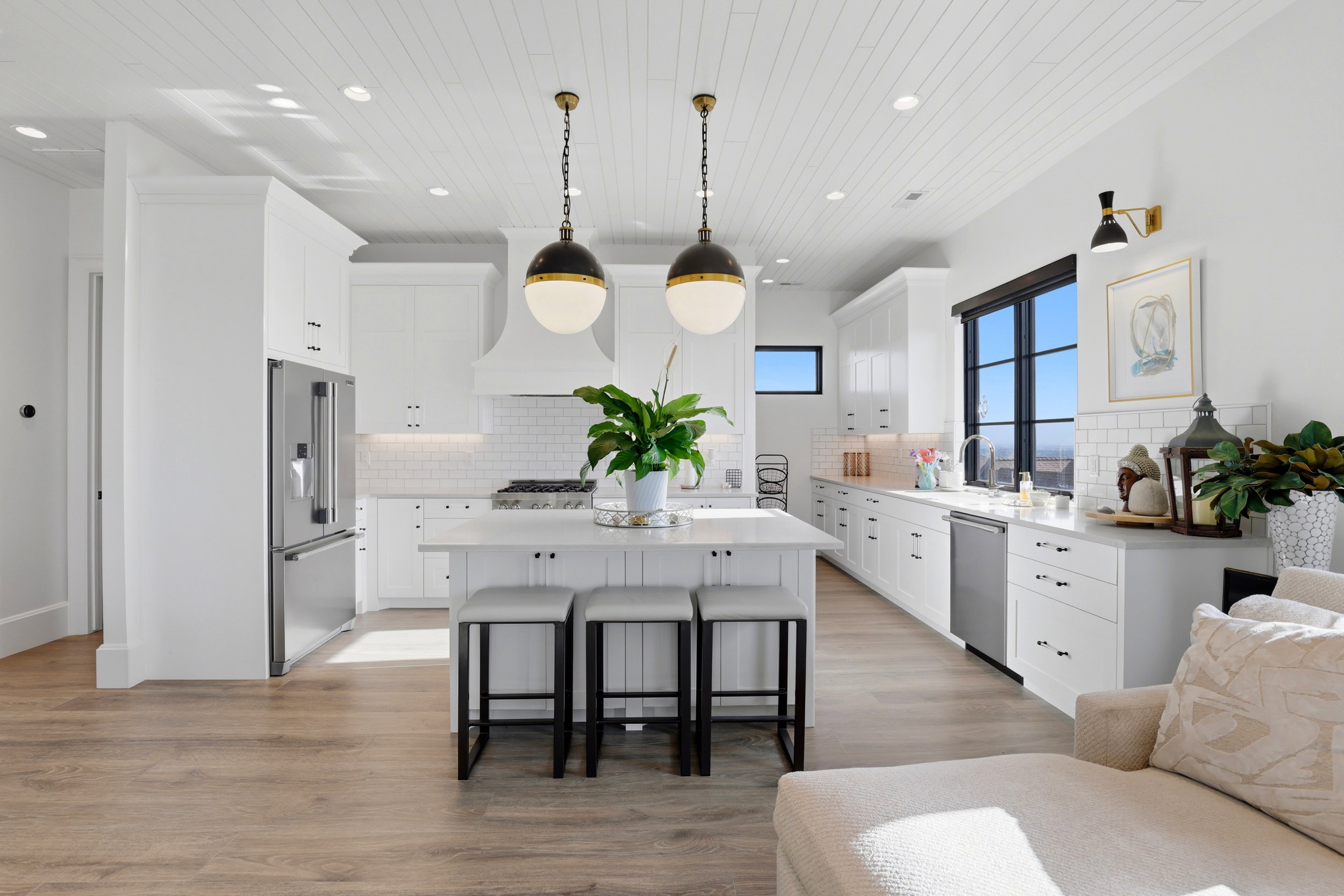 Kitchen with a kitchen bar, a center island, white cabinets, light wood-style flooring, and stainless steel appliances