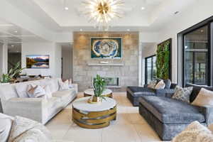 Living area featuring a tile fireplace, suspended lighting, and light tile patterned floors