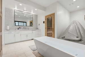 Bathroom featuring vanity, a sauna, tasteful backsplash, recessed lighting, and a freestanding bath
