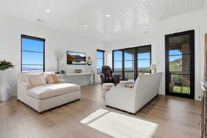 Living area featuring light wood-style flooring, wood ceiling, and recessed lighting