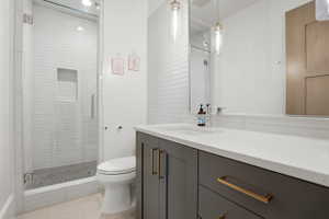 Full bathroom featuring vanity, a shower stall, and light tile patterned floors