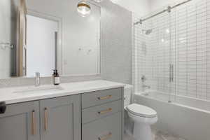 Full bath with vanity and shower / bath combination with glass door