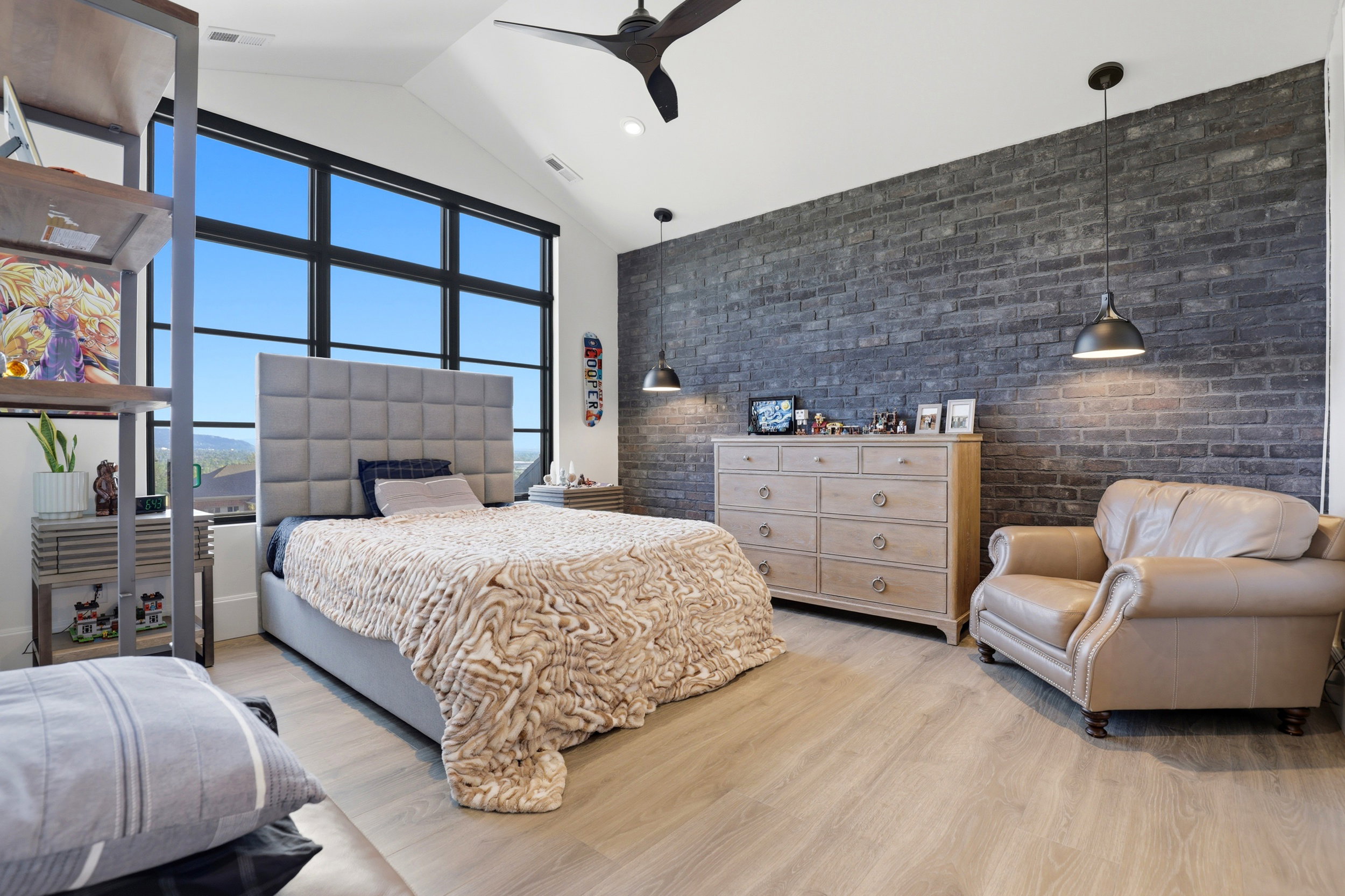 Bedroom featuring brick wall, light wood-style floors, a high ceiling, recessed lighting, and ceiling fan