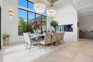 Dining space featuring a high ceiling, suspended lighting, light tile patterned flooring, and a mountain view