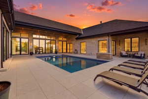 Integrated pool / hot tub featuring a patio area