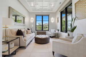 Sitting room with coffered ceiling and light tile patterned floors