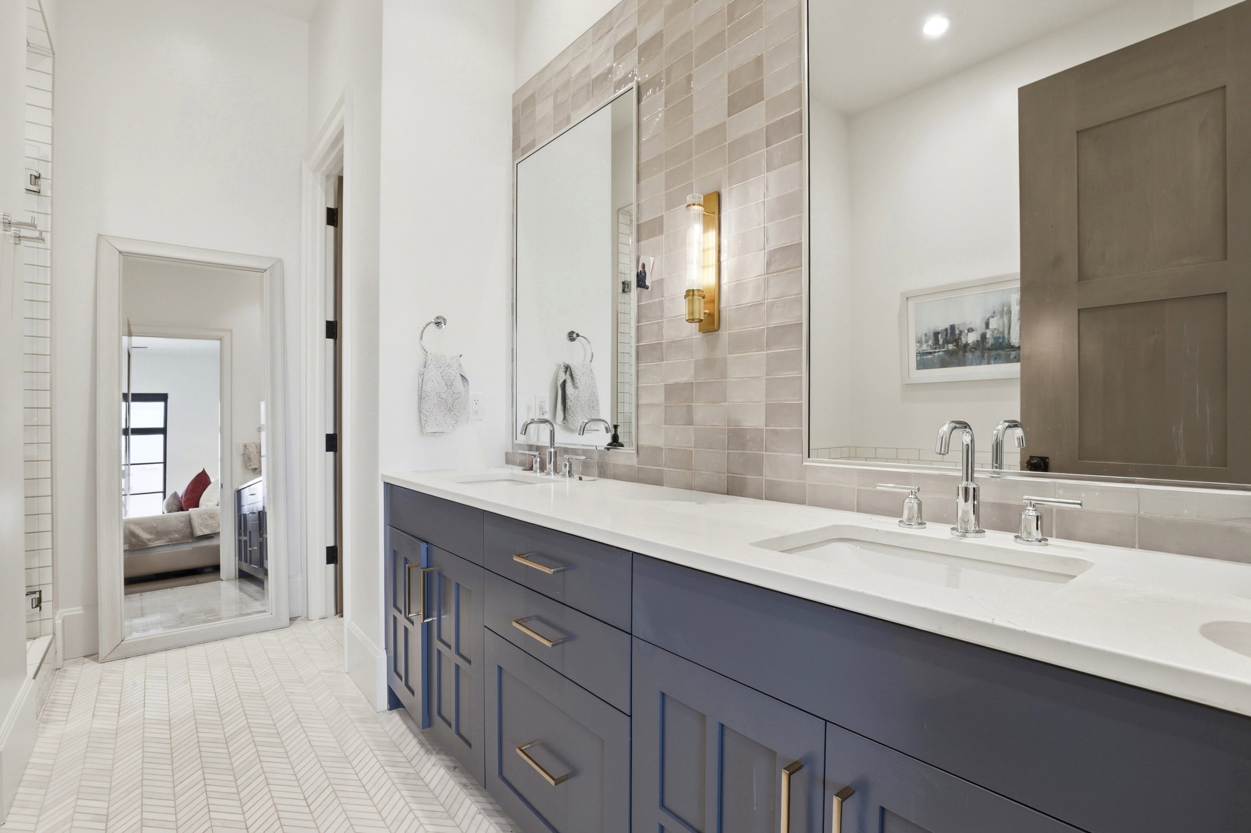 Bathroom featuring double vanity, light tile patterned flooring, and ensuite bathroom