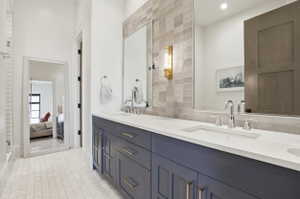 Bathroom featuring double vanity, light tile patterned flooring, and ensuite bathroom