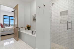 Bathroom with ensuite bath, a shower stall, light tile patterned floors, and a bath