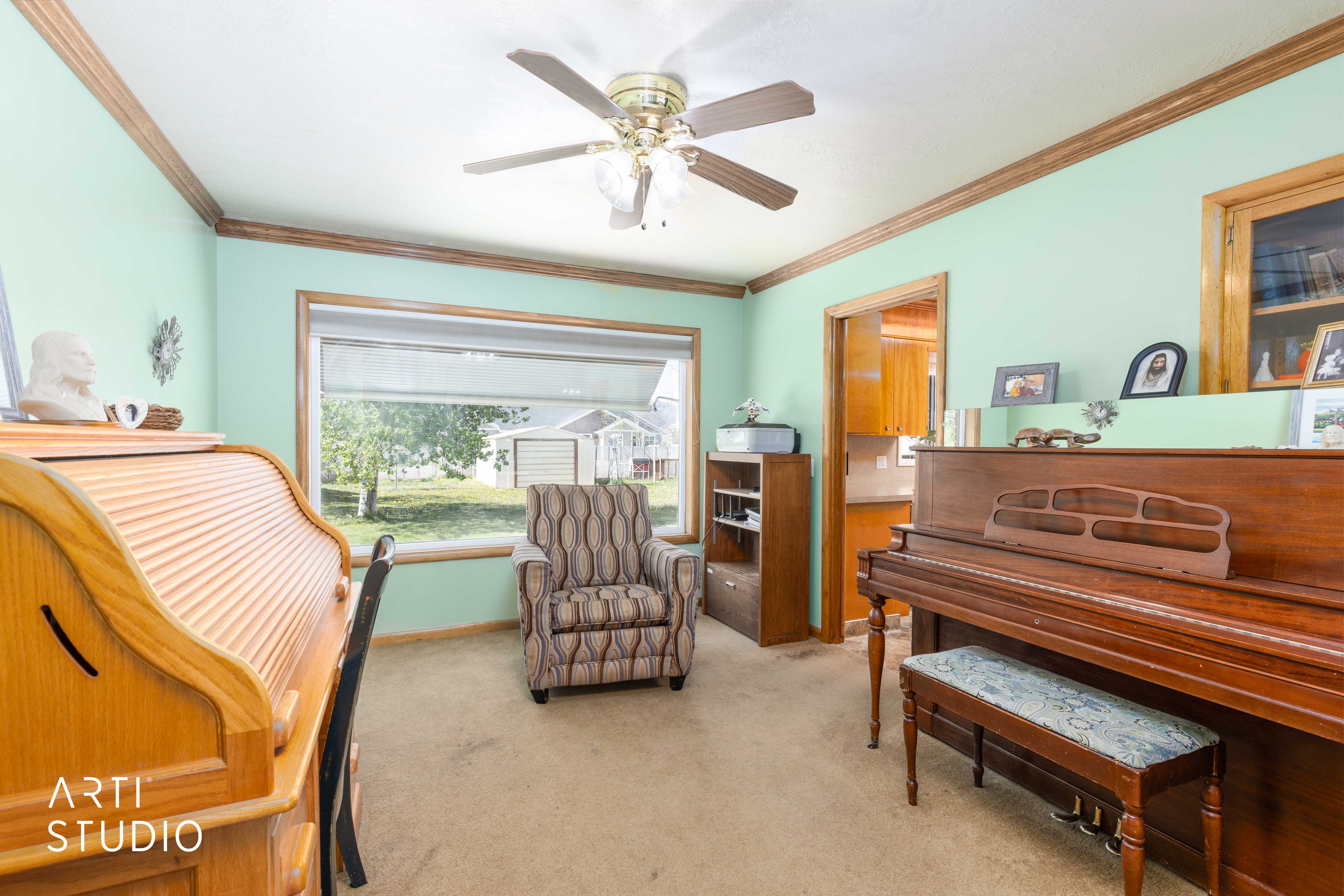 Living area with light colored carpet, a ceiling fan, and ornamental molding