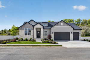 View of front facade featuring a garage, stone siding, driveway, a shingled roof, and board and batten siding