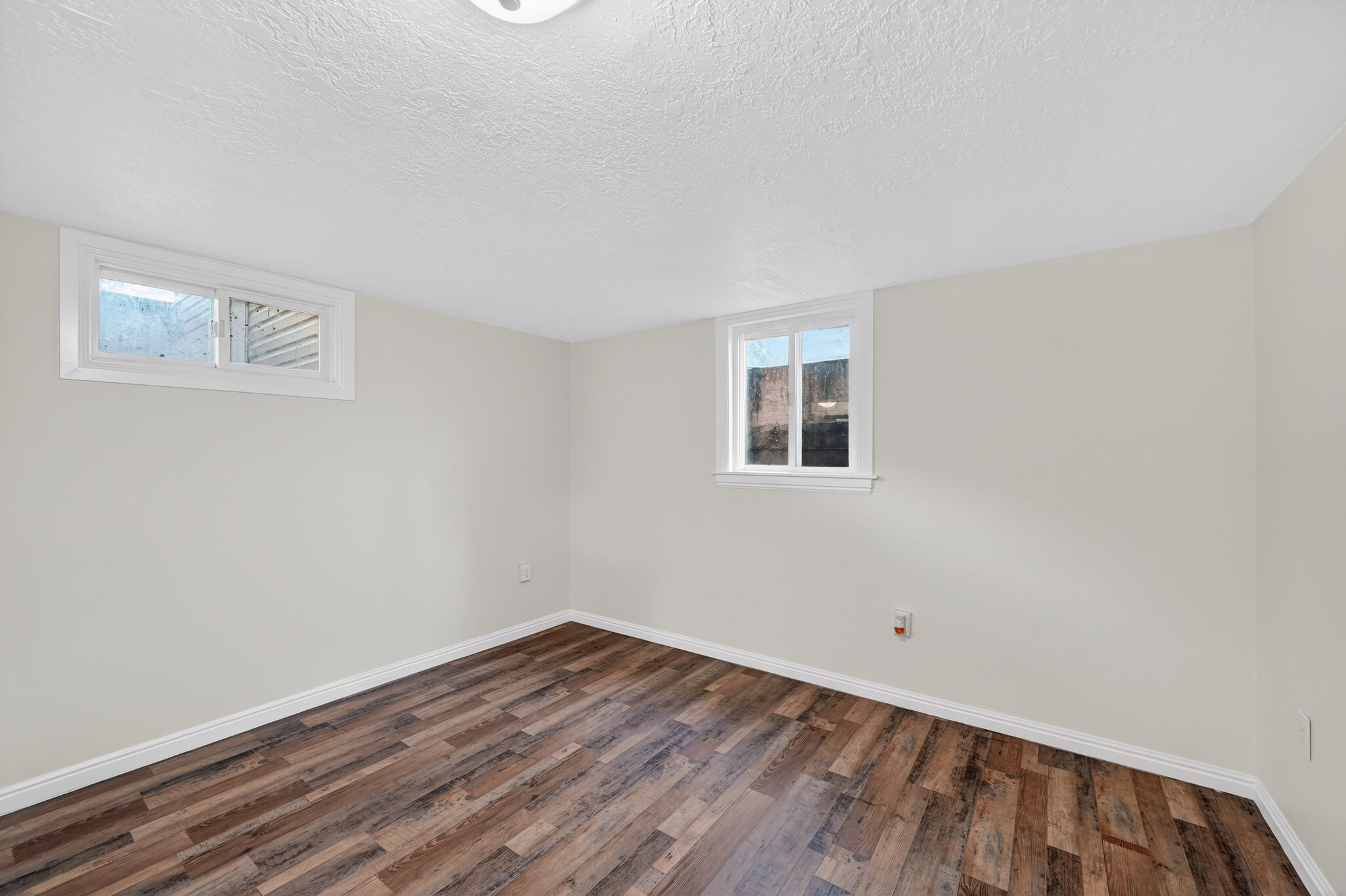 Basement with dark wood-style floors and a textured ceiling