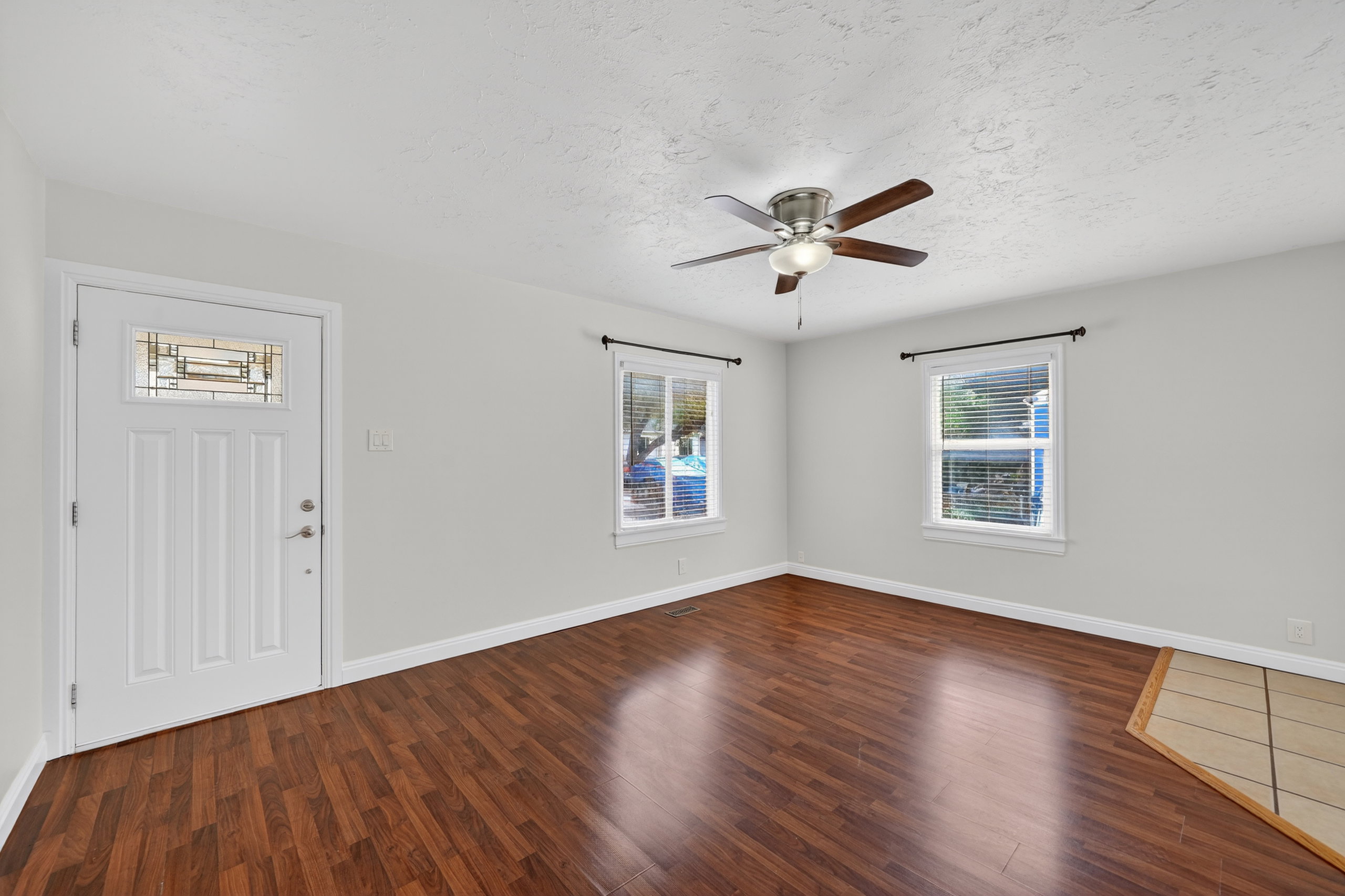 Foyer with dark wood finished floors, ceiling fan, and a textured ceiling