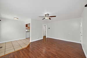 Empty room featuring dark wood-type flooring and ceiling fan