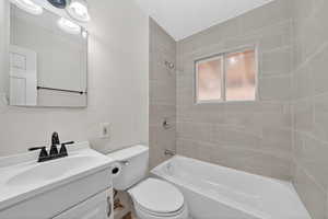 Full bath featuring vanity, a textured ceiling, bathing tub / shower combination, and a textured wall