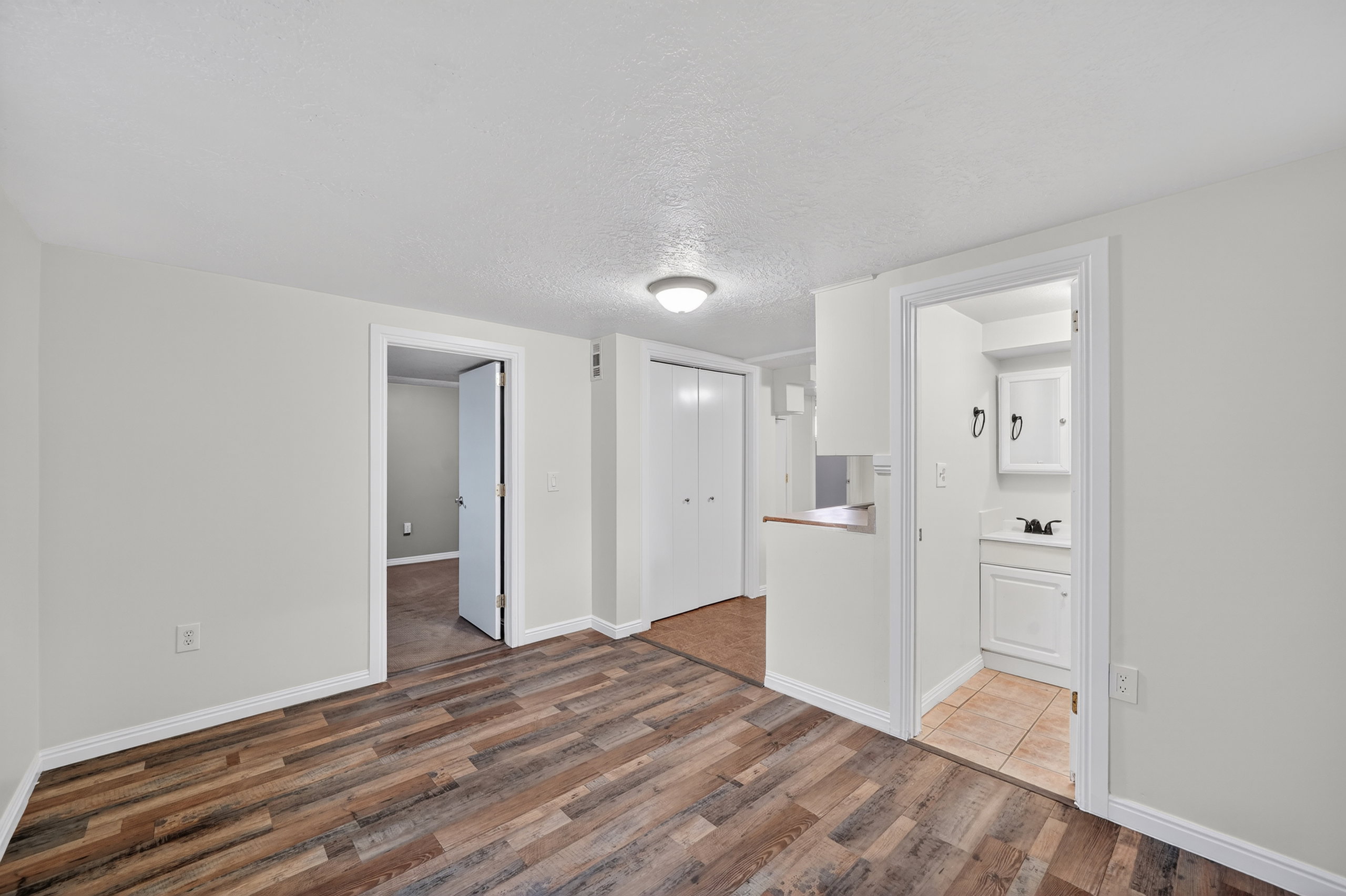 Spare room featuring a textured ceiling and dark wood-style flooring