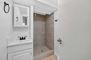 Full bathroom featuring a shower stall, vanity, and light tile patterned floors