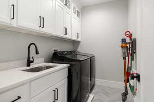 Laundry area featuring cabinet space and independent washer and dryer