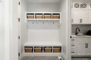 Mudroom featuring a sink and baseboards