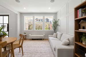 Living area featuring a decorative wall, light wood-type flooring, and a textured ceiling