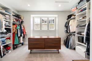 Walk in closet featuring light colored carpet