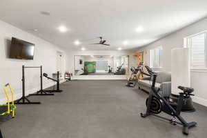 Exercise room with a ceiling fan and a textured ceiling