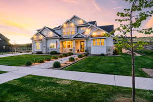 Craftsman-style house with stone siding, board and batten siding, a porch, and a lawn