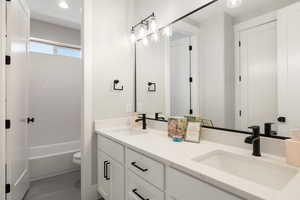 Bathroom with double vanity, tub / shower combination, and recessed lighting