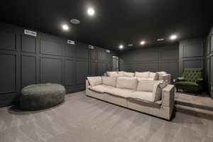 Cinema room featuring a decorative wall, light carpet, and recessed lighting