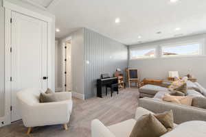 Living area featuring light colored carpet, a textured ceiling, and recessed lighting