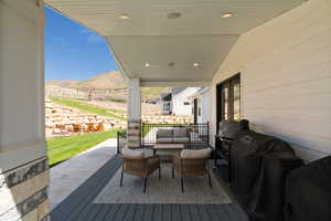 Deck featuring outdoor lounge area, a mountain view, grilling area, a patio area, and french doors