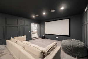 Cinema room with light colored carpet and recessed lighting