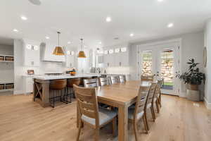 Dining room with french doors, recessed lighting, and light wood-style flooring