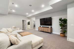 Living room with light carpet and recessed lighting