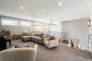 Living area with carpet floors, recessed lighting, and a textured ceiling