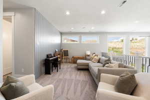 Living room featuring a textured ceiling, recessed lighting, and light colored carpet