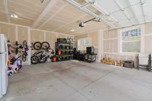 Garage featuring freestanding refrigerator and a garage door opener