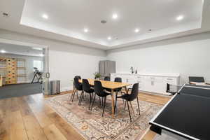 Dining space featuring a tray ceiling, recessed lighting, and light wood-style flooring