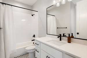 Full bathroom with vanity, shower / tub combo, and tile patterned floors