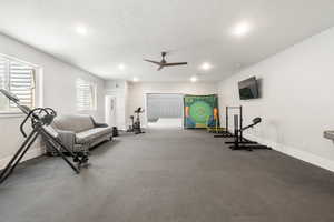 Exercise area featuring ceiling fan, a textured ceiling, and recessed lighting