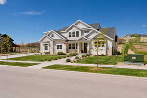 Craftsman-style house with a porch, board and batten siding, stone siding, and a standing seam roof