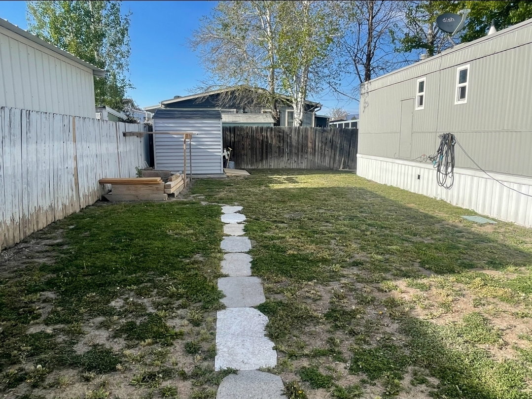 Fenced backyard with a storage shed