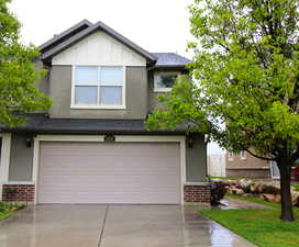 View of front of house featuring brick siding, a 2-car garage, stucco siding, concrete driveway, and a shingled roof