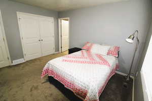 Carpeted bedroom with an ensuite bathroom and baseboards