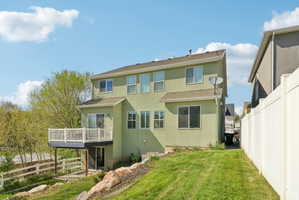 Rear view of property with stucco siding, a deck, and a shingled roof